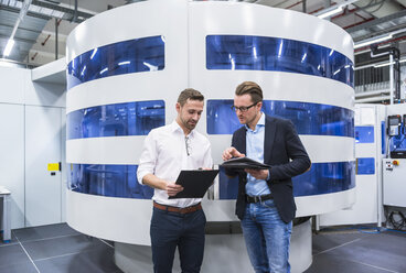 Two men talking in factory shop floor - DIGF02174