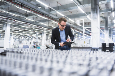 Man looking at products in factory shop floor - DIGF02187