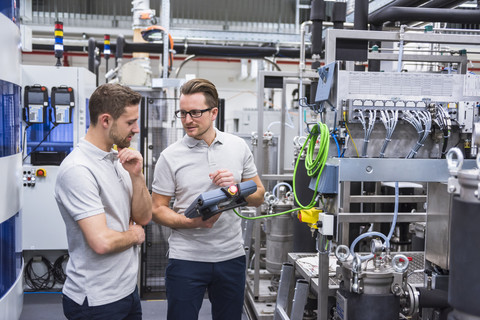 Two men with control in factory shop floor stock photo