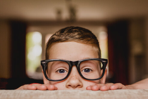 Portrait of peeking boy wearing oversized glasses - NMSF00058