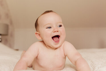 Porträt eines lachenden kleinen Mädchens auf dem Bett - NMSF00064