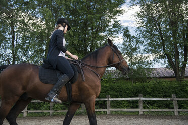 Junge Frau reitet auf einem Pferd - ZOCF00237