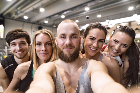 Junge Sportler haben Spaß im Fitnessstudio und machen Selfies, lizenzfreies Stockfoto