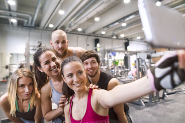 Four women in fitness wear standing together for a selfie after