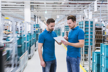 Zwei Männer mit Tablet im Gespräch in einer Industriehalle - DIGF02218