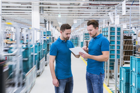 Zwei Männer mit Tablet im Gespräch in einer Industriehalle - DIGF02218