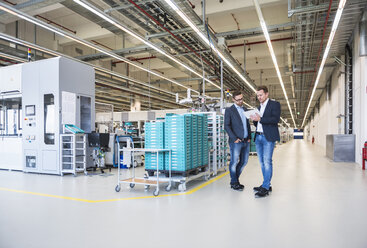 Two men with tablet talking in factory shop floor - DIGF02257