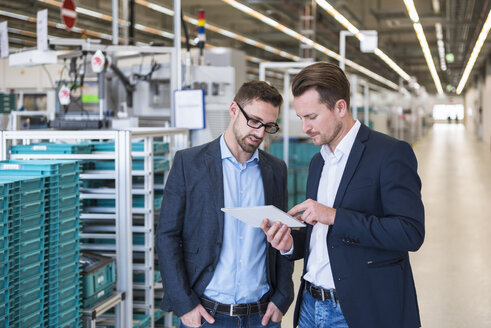 Zwei Männer mit Tablet im Gespräch in einer Fabrikhalle - DIGF02259