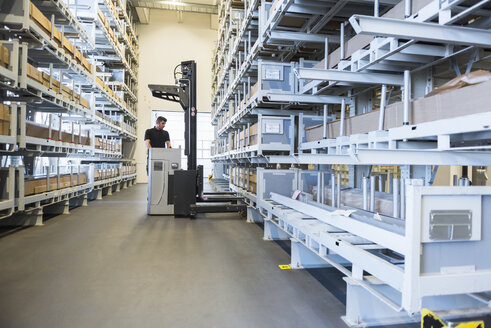 Worker with forklift in factory warehouse - DIGF02311