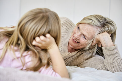 Ältere Frau entspannt sich mit ihrer Enkelin auf dem Bett - SRYF00280