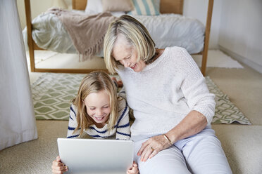 Little girl and her grandmother using tablet at home - SRYF00294