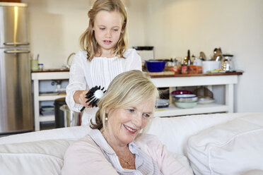 Little girl brushing hair of her grandmother - SRYF00307