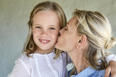 Portrait of smiling little girl kissed by her mother - SRYF00322