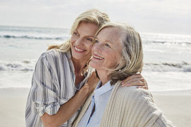 Ältere Frau und ihre erwachsene Tochter stehen am Strand und umarmen sich - SRYF00345