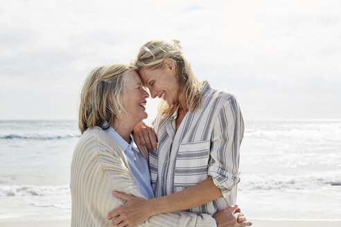 Ältere Frau und ihre erwachsene Tochter stehen am Strand und umarmen sich - SRYF00347