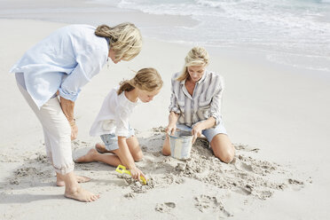 Family playing with sand on the beach - SRYF00359