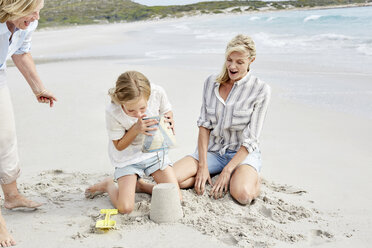 Family playing with sand on the beach - SRYF00360