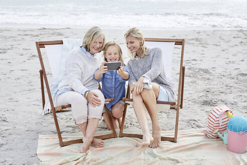 Mutter, Tochter und Großmutter machen Selfies am Strand - SRYF00377