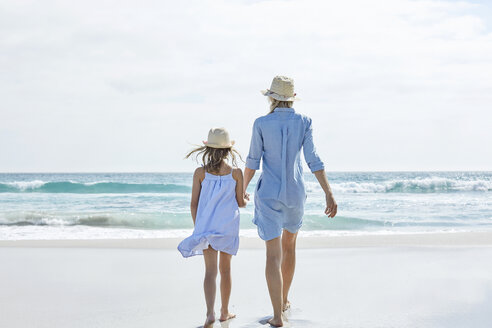 Mother and daughter walking by the sea, rear view - SRYF00405