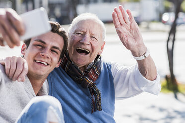 Happy senior man and adult grandson taking a selfie - UUF10430