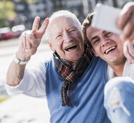 Happy senior man and adult grandson taking a selfie - UUF10431