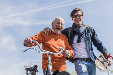 Porträt eines glücklichen älteren Mannes mit einem erwachsenen Enkel in Bewegung - UUF10445