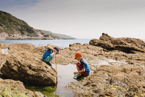 UK, England, Cornwall, Polkerris beach, two boys fishing at the coast stock photo