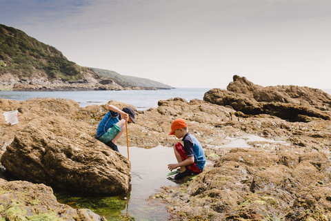 UK, England, Cornwall, Polkerris Strand, zwei Jungen beim Angeln an der Küste, lizenzfreies Stockfoto