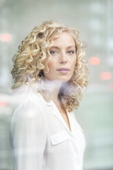 Porträt einer blonden Geschäftsfrau hinter einer Fensterscheibe - PESF00519