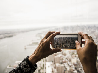 USA, New York City, taking cell phone picture of the skyline - UUF10476