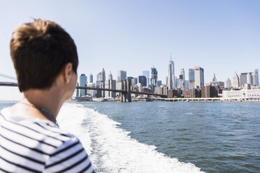 USA, New York City, Frau auf Fähre mit Skyline von Manhattan im Hintergrund - UU10478