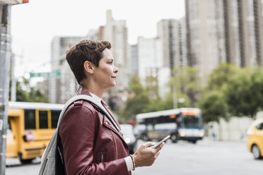 USA, New York City, woman with cell phone in the city - UUF10483