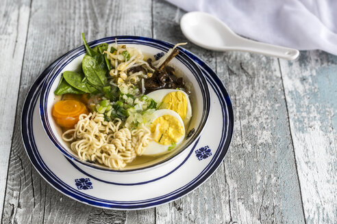 Schüssel Ramen-Suppe mit Spinat, Karotten, gekochtem Ei, Bambussprossen und Pilzen - SARF03317