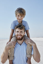 Porträt eines Vaters, der seinen Sohn am Strand huckepack trägt - RORF00764