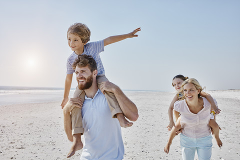 Glückliche Familie beim Spaziergang am Strand, lizenzfreies Stockfoto
