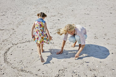 Mother and daughter drawing heart on the beach - RORF00767