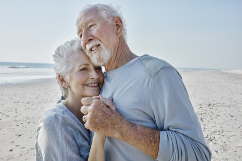 Glückliches älteres Paar tanzt am Strand, lizenzfreies Stockfoto