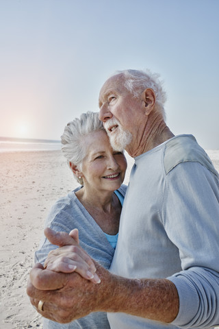 Glückliches älteres Paar tanzt am Strand, lizenzfreies Stockfoto