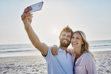 Ein glückliches Paar macht ein Selfie am Strand - RORF00807