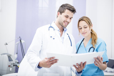 Two smiling doctors holding folder - WESTF22982