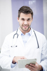 Porträt eines lächelnden Arztes mit Tablet - WESTF22991