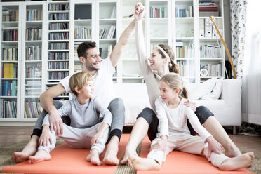 Happy family doing gymnastics at home - WESTF22996