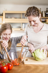 Mother and daughter preparing salad in kitchen - WESTF23015