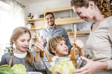 Family preparing salad in kitchen - WESTF23017