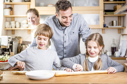 Familie bereitet Baguette in der Küche zu, lizenzfreies Stockfoto