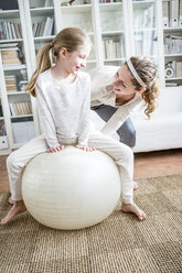 Mother and daughter with fitness ball at home - WESTF23030