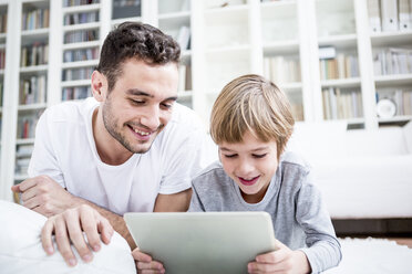 Father and son using tablet at home - WESTF23034