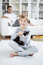Lächelnder Junge streichelt Katze zu Hause - WESTF23036