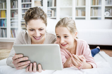 Mother and daughter using tablet at home - WESTF23038