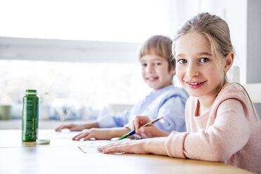 Brother and sister painting at table - WESTF23049